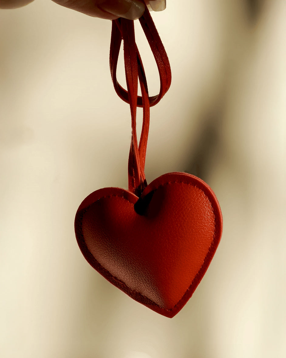 LoveBeats Heart Puffy Charm, a red high-quality faux leather heart keychain hanging by a red strap, a cute tote accessory.