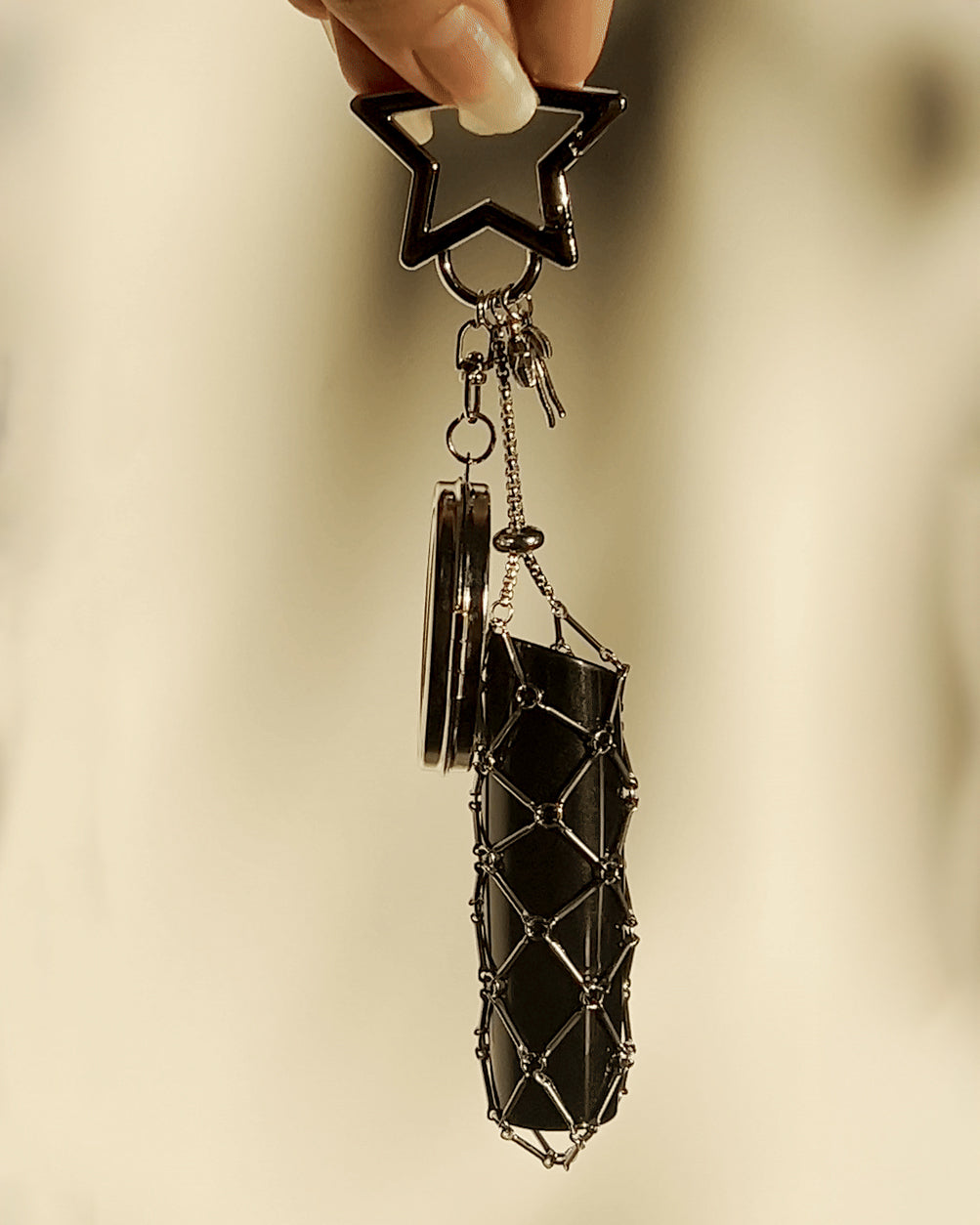 Elegant silver star keychain with woven mesh lipstick holder and a polished mirror, a chic LoveBeats bag accessory.