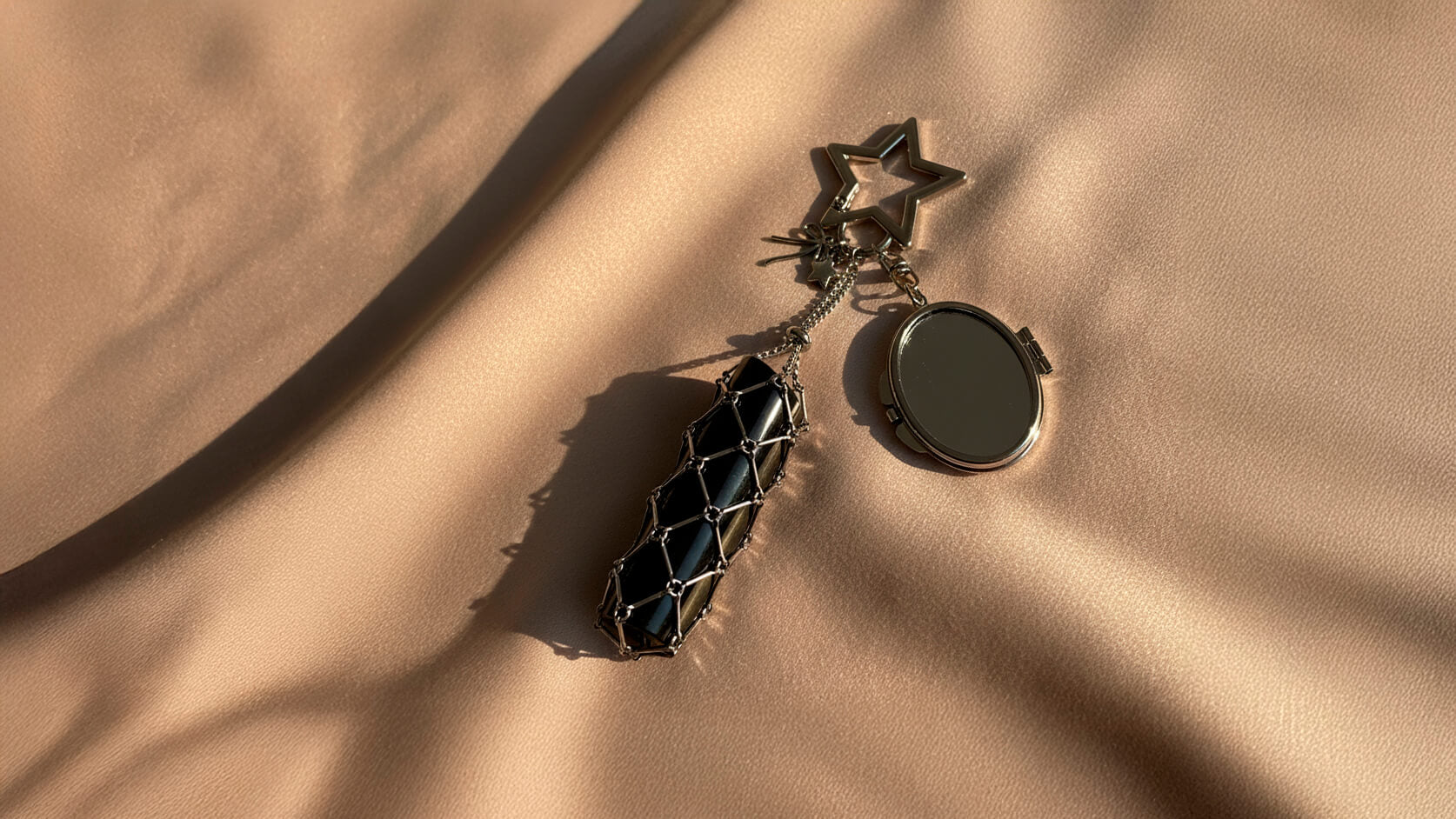 Star Lipstick Charm Holder by Love BEATS – elegant lipstick charm holder resting on a shiny beige fabric under sunset light.